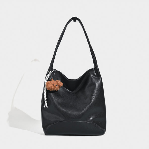 Slouchy leather-look shoulder tote with bear charm tassel in black and coffee brown, front view
