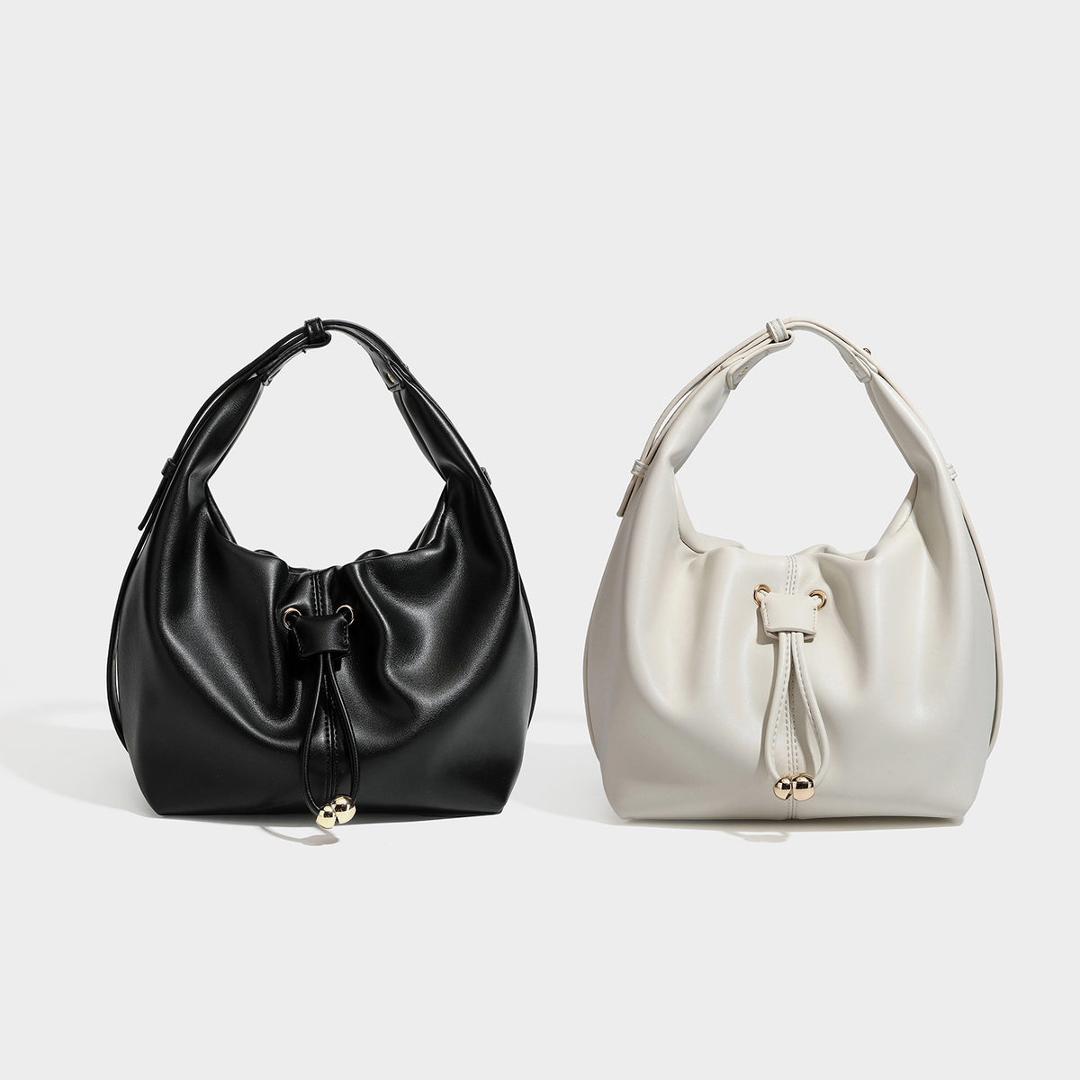 Slouchy hobo bag with smooth leather-look finish, drawstring cinch closure, and gold-tone bead hardware, detail view 2