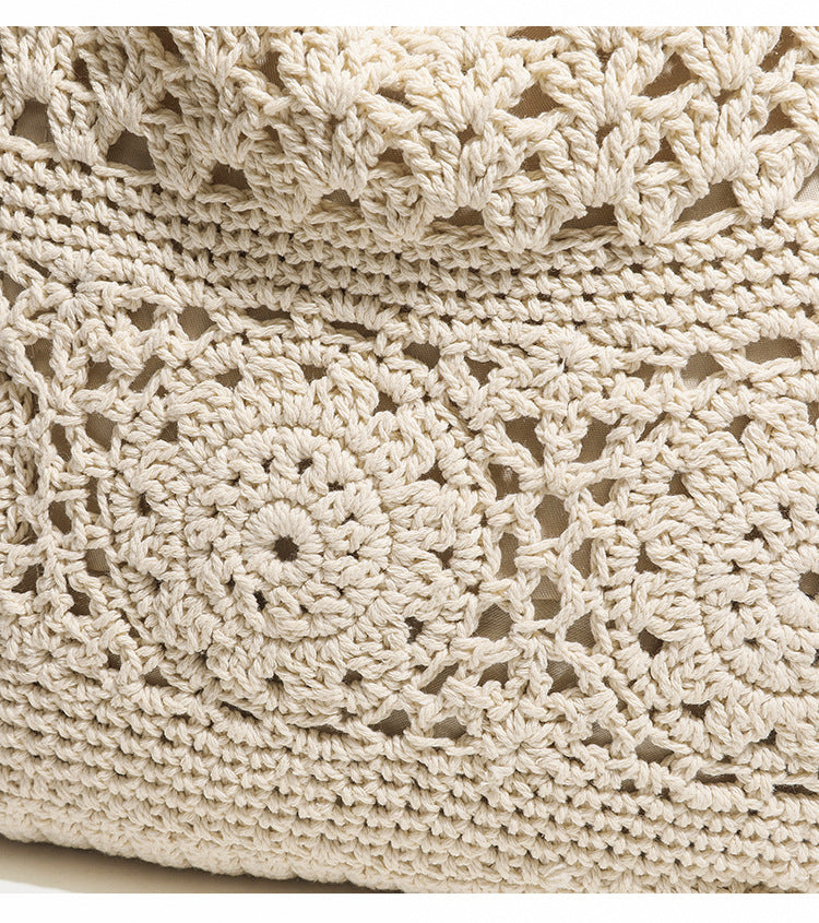 Cream openwork floral crochet tote bag with tassel and wooden bead charm and long rope shoulder straps, detail view 7