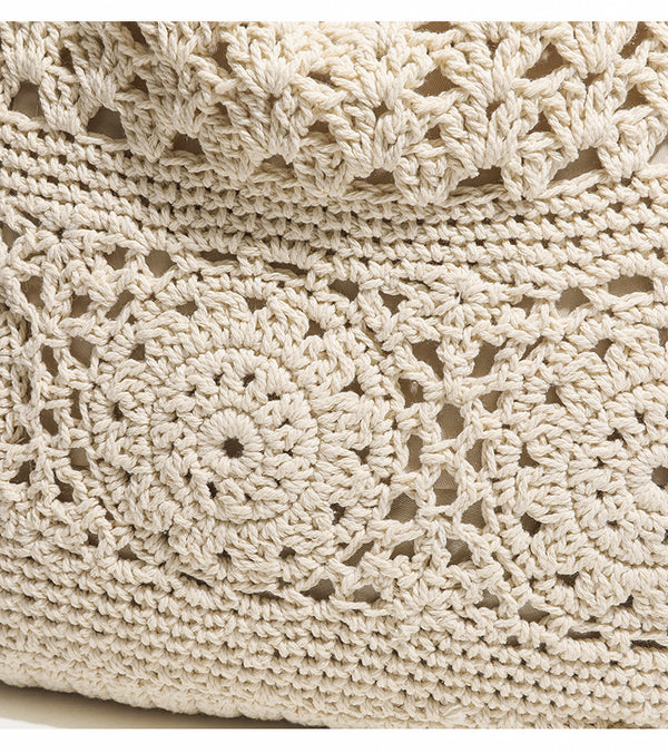 Cream openwork floral crochet tote bag with tassel and wooden bead charm and long rope shoulder straps, detail view 7