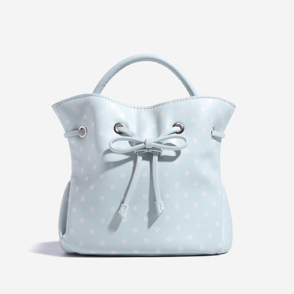 Cream white polka-dot drawstring bucket bag with black leather-look top handle and bow-tied cord closure, detail view 6