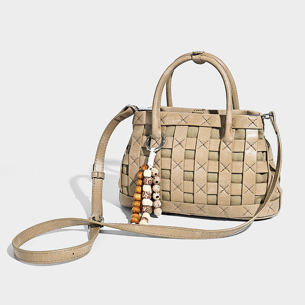 Small structured woven satchel tote with rounded top handles, silver-tone ring hardware, and bead tassel charm, detail view 3