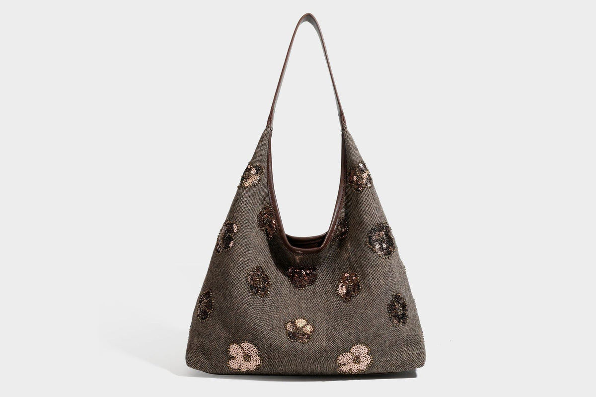 Lässig fallende, trapezförmige Schulter-Tote in Anthrazitgrau mit floralen Paillettenmotiven in Silber, Riemen in Lederoptik und herabhängendem Perlenbesatz