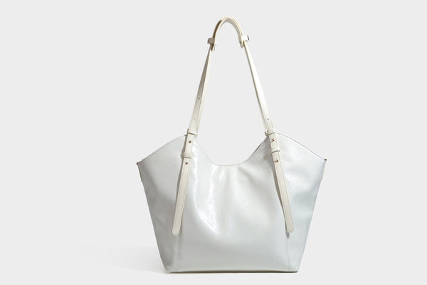 Große, glänzende Tote-Bag aus schwarzem Lederimitat mit geknitterter Optik, lässig fallender Trapezsilhouette, zwei Schulterriemen und goldfarbenen