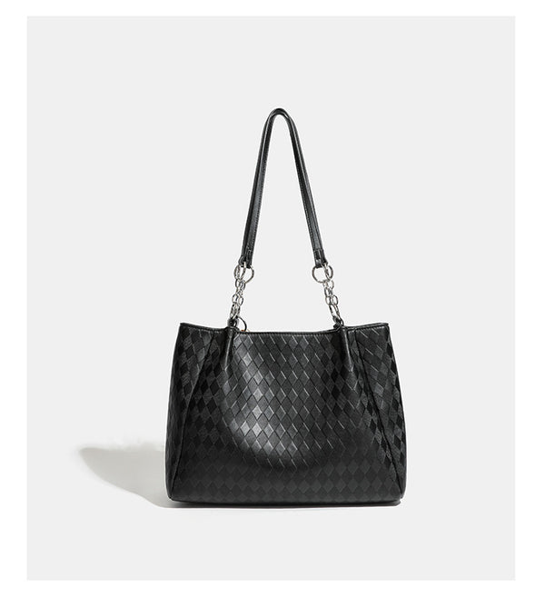 Black diamond-quilted leather-look tote bag with silver chain-ring shoulder straps and plush bear charm pendant, detail view