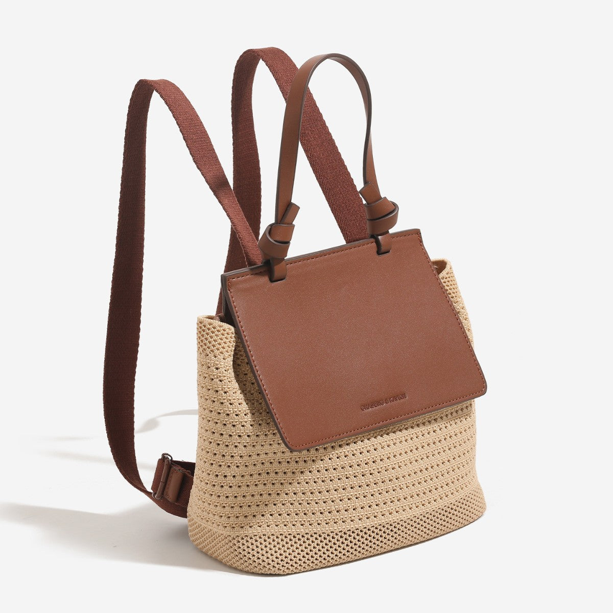 Small structured woven-body flap bag with smooth leather-look front panel, knotted top handle, and wide adjustable shoulder