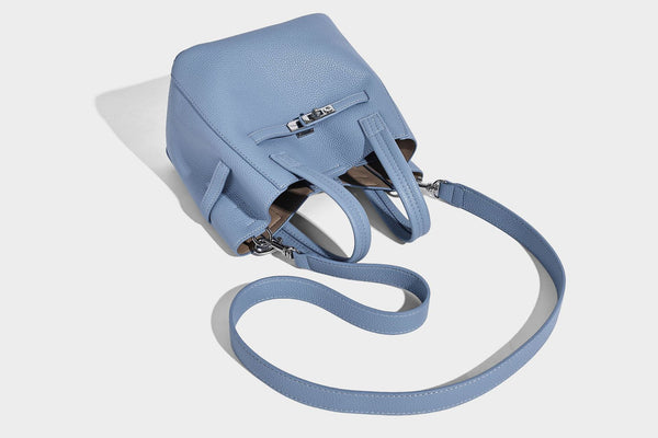 Small structured pebbled bucket tote bag with dual top handles, silver turn-lock front pocket, and detachable shoulder strap