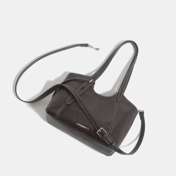 Structured leather-look tote shoulder bag with double crossed straps, contrast topstitching, and metal bar hardware, detail