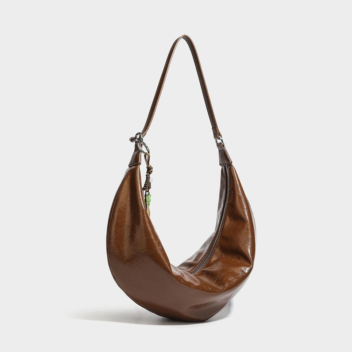 Lässige sichelförmige Hobo-Schultertasche aus glänzender, geknautschter Lederoptik mit schmalem Riemen, silberfarbenem Ringbeschlag und