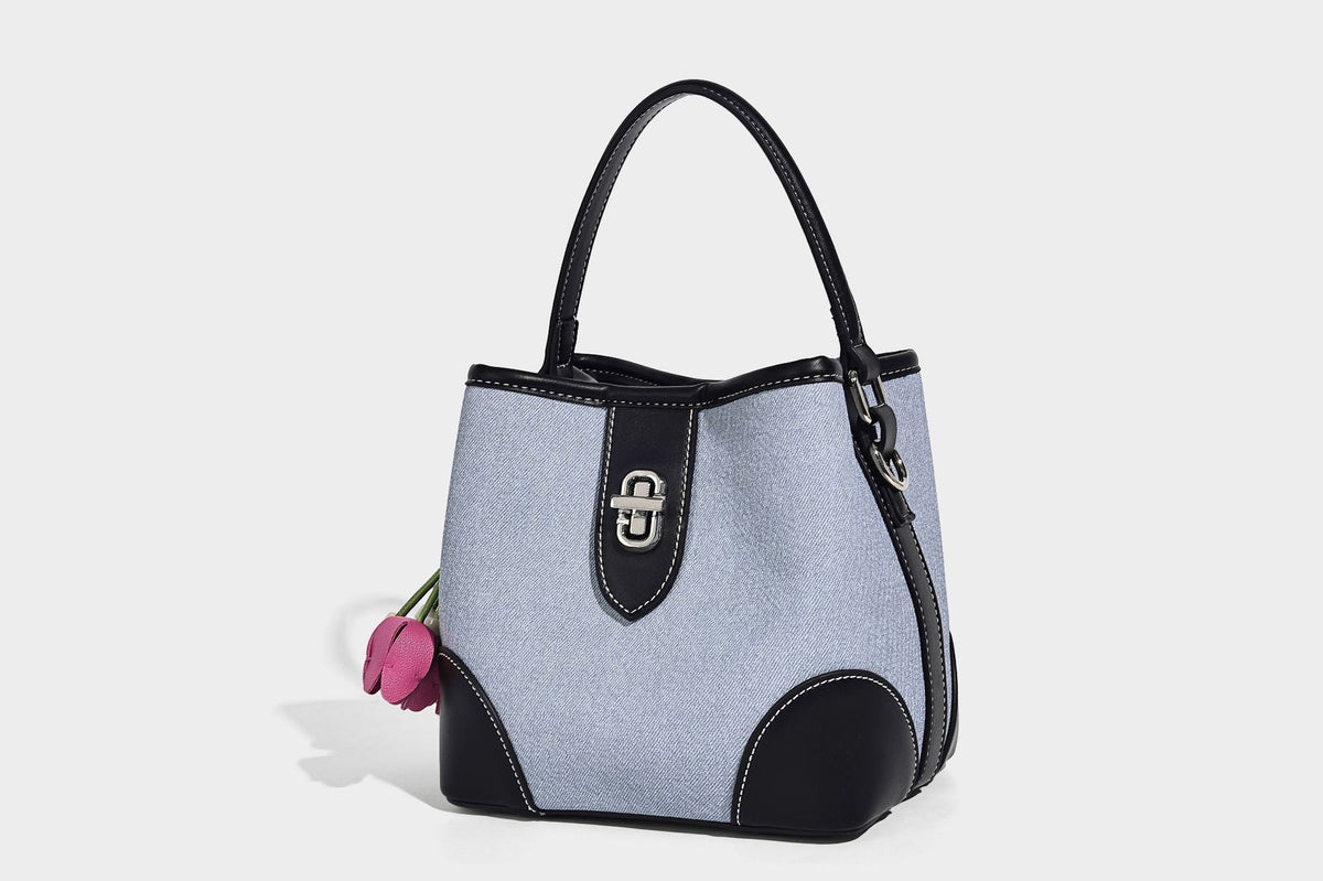 Small structured bucket bag in denim-look light blue fabric with black leather-look trim, silver turn-lock hardware, short