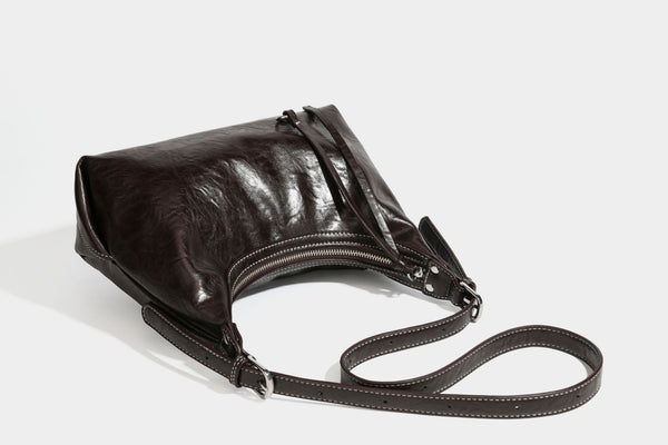 Slouchy hobo shoulder bag in glossy crinkled leather-look finish with zip-top closure and silver-tone ring hardware, detail