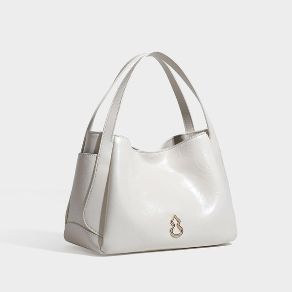 Black glossy crinkled leather-look convertible shoulder tote bag with gold gourd-shaped emblem hardware and detachable