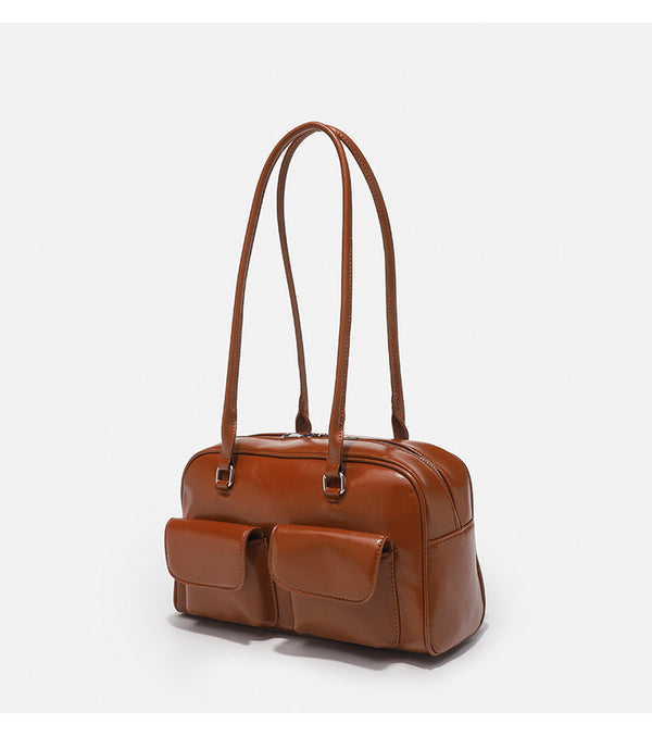 Structured glossy leather-look bowling shoulder bag with two front flap pockets, top zip closure, and long double shoulder
