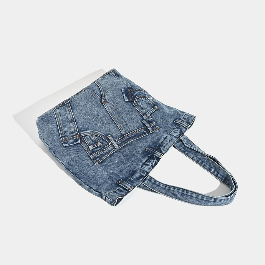 Large washed denim tote bag with jeans-style patch pocket and riveted seam detailing, double shoulder straps, open top