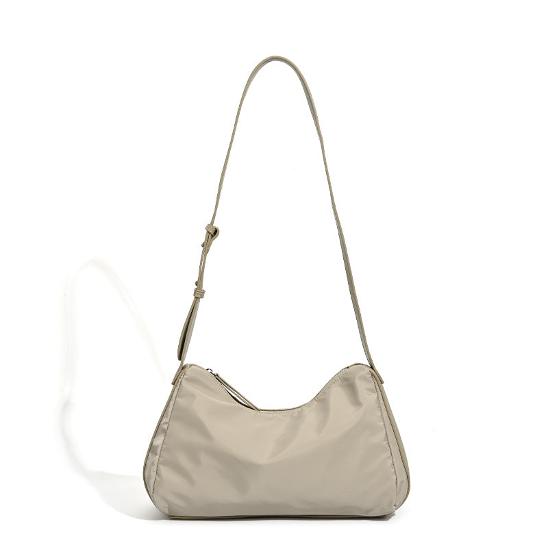 Soft crescent shoulder bag in smooth sheen nylon with contrast leather-look trim, slim adjustable strap, and top zip closure