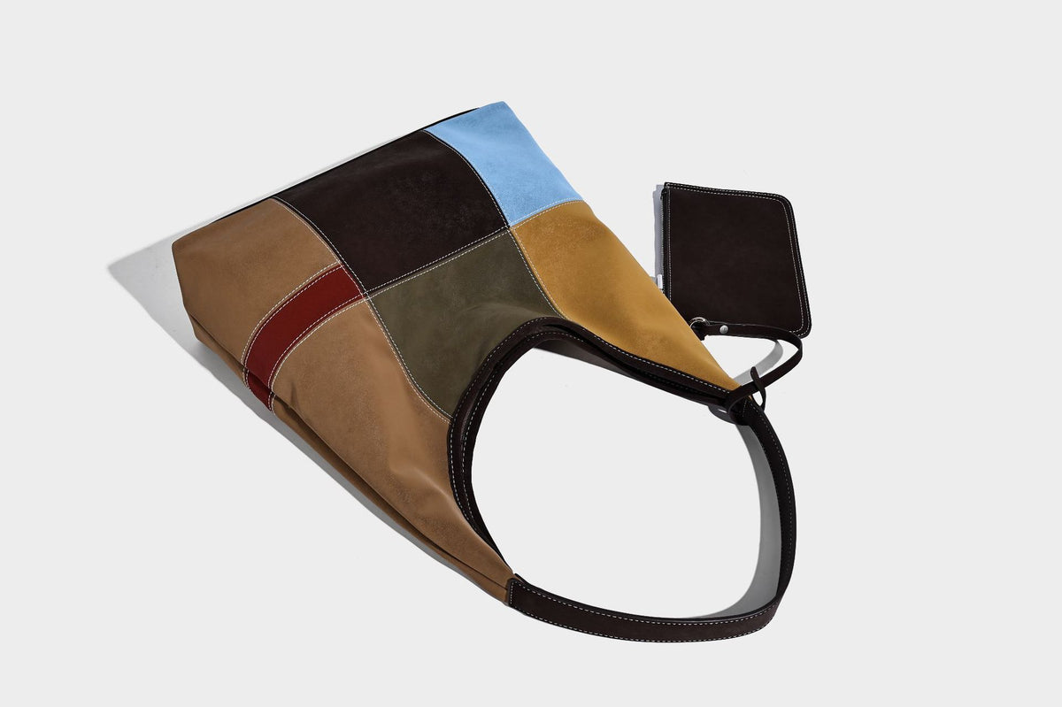 Multicolor patchwork hobo shoulder bag with brown tan olive mustard red and blue suede-look panels, contrast white stitching