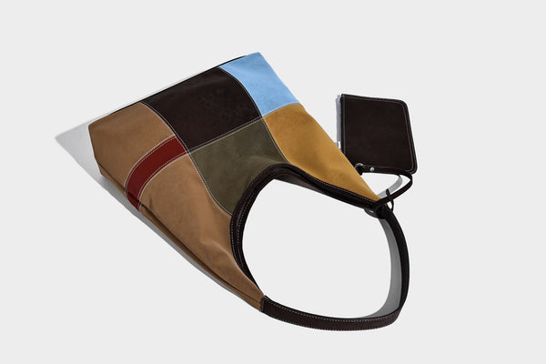 Multicolor patchwork hobo shoulder bag with brown tan olive mustard red and blue suede-look panels, contrast white stitching