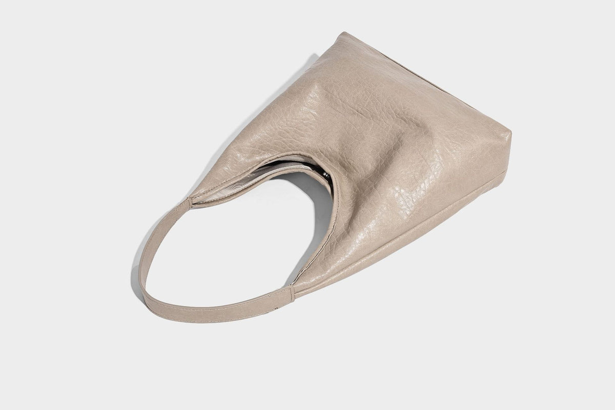 Slouchy hobo shoulder bag in pale yellow glossy pebbled leather-look finish with single shoulder strap and detachable front