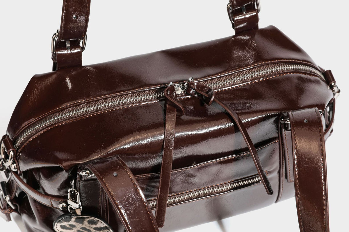 Strukturierte Schultertasche in glänzender Lederoptik mit abgerundetem Korpus, silberfarbenen Beschlägen, Reißverschlussfach auf der Vorderseite und Leopardenmuster