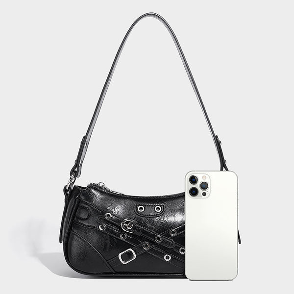 Compact moto-inspired shoulder bag with crisscross grommet strap detail, glossy textured finish, and adjustable crossbody