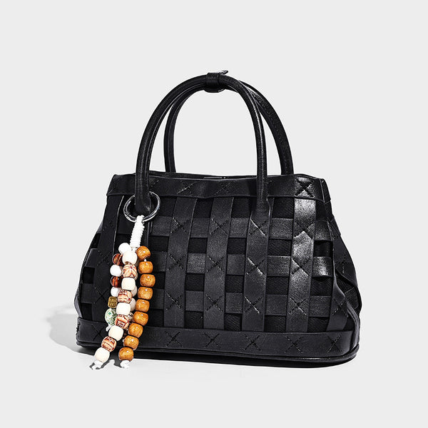 Small structured woven satchel tote with rounded top handles, silver-tone ring hardware, and bead tassel charm, detail view 6