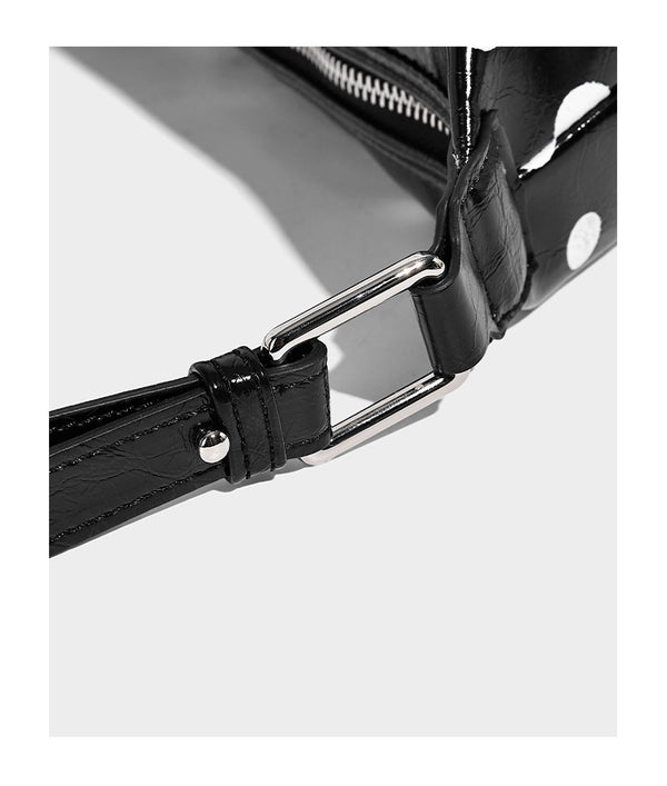 Schultertasche in glänzender Lederoptik mit Punktemuster, aufgesetztem Mini-Fronttäschchen, Reißverschluss oben und verstellbarem Riemen, Detailansicht