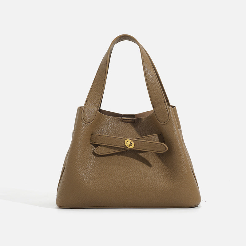 Pebbled trapezoid tote bag with gold turn-lock strap detail and matching snap pouch, detail view 2