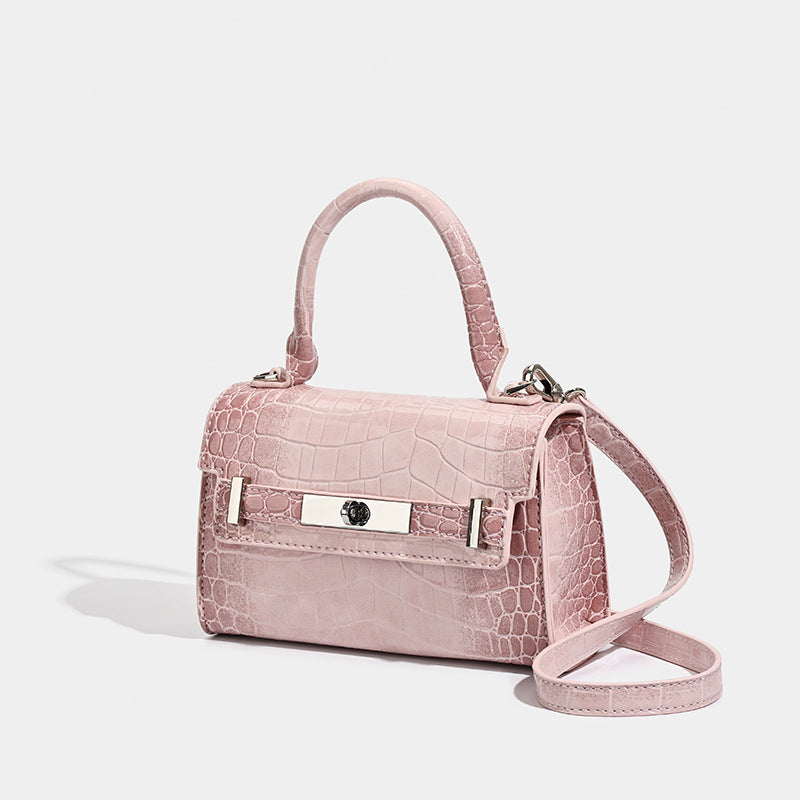Strukturierte Mini-Henkeltasche in glänzender Lederoptik mit Krokoprägung und silberfarbenem Drehverschluss und