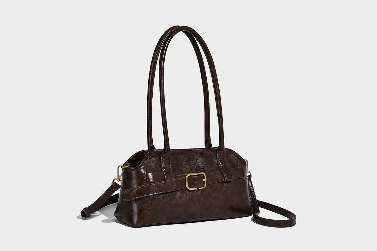 Strukturierte dunkelbraune Henkeltasche mit Öl-Wachs-Finish, vorderer Gürtelschnalle, goldfarbenen Beschlägen und zwei Tragegriffen, Detailansicht