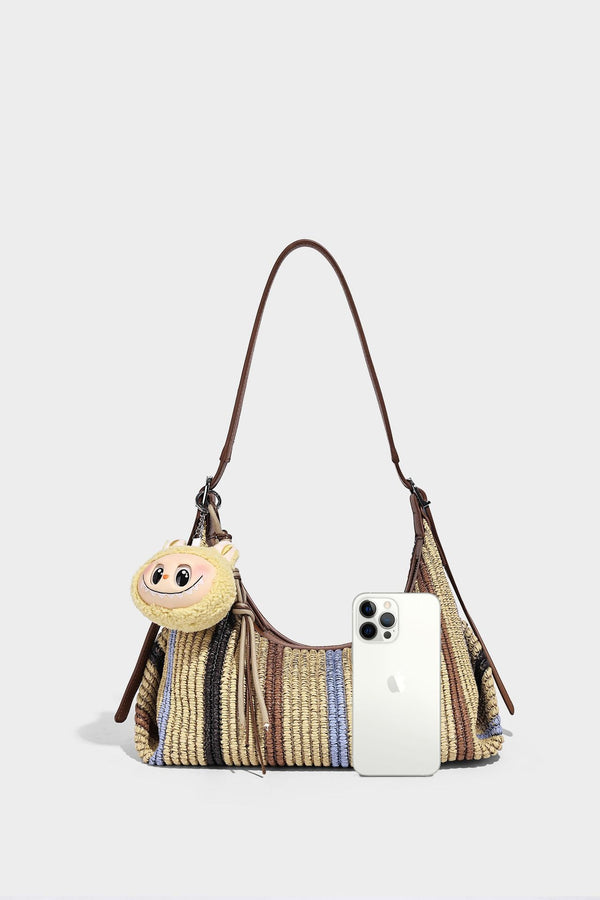 Slouchy woven straw hobo shoulder bag with beige, black, brown, and blue vertical stripes and brown leather-look trim, detail