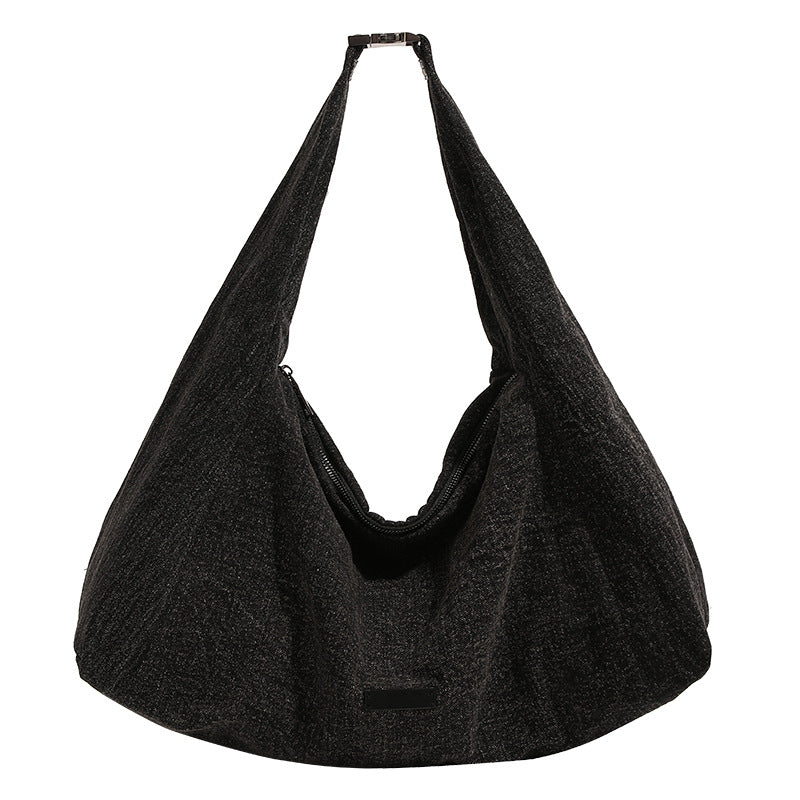 Oversized slouchy hobo shoulder bag in dark marled denim-texture fabric with top zip closure and adjustable single strap