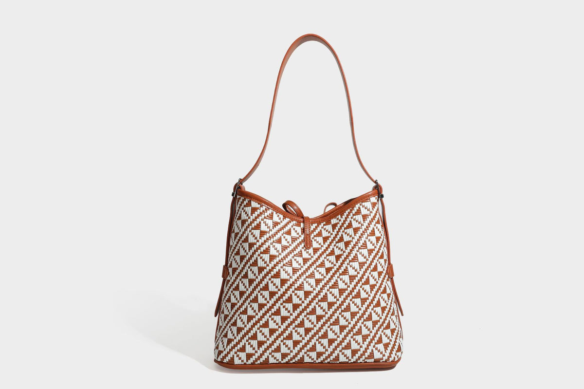 Woven geometric bucket shoulder bag in white and dark brown two-tone pattern with leather-look trim and drawstring top