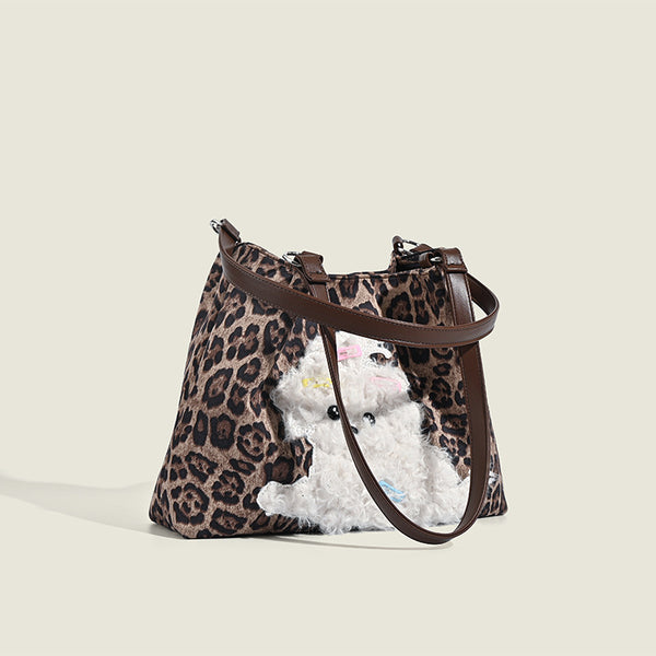 Leopard-print fabric tote bag with white plush teddy bear appliqué and brown leather-look shoulder straps, detail view 2