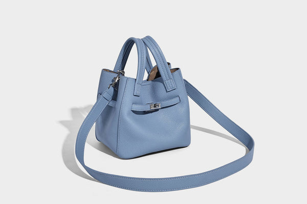 Small structured pebbled bucket tote bag with dual top handles, silver turn-lock front pocket, and detachable shoulder strap