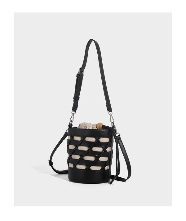 Small cylindrical woven lattice bucket bag with leather-look black trim, beige canvas body, wooden bead drawstring closure