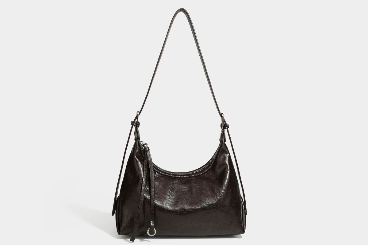 Slouchy hobo shoulder bag in glossy crinkled leather-look finish with zip-top closure and silver-tone ring hardware, detail