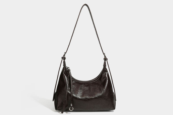 Slouchy hobo shoulder bag in glossy crinkled leather-look finish with zip-top closure and silver-tone ring hardware, detail