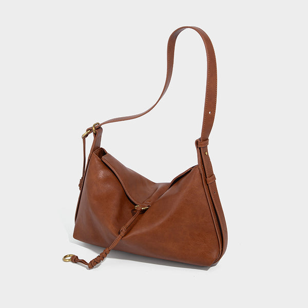 Slouchy brown leather-look shoulder bag with knotted drawcord tie closure, gold-tone ring hardware, and long adjustable