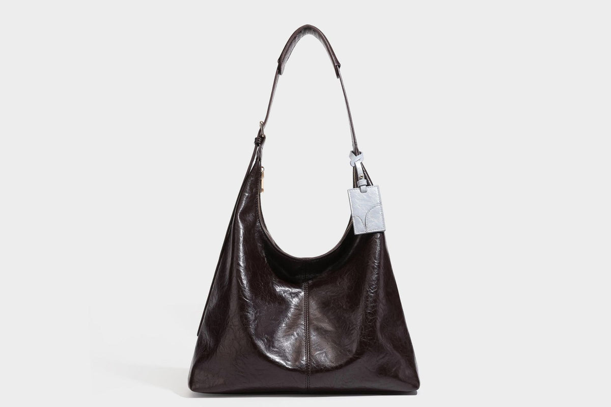 Große dunkelbraune, glänzende, geknautschte Hobo-Schultertasche mit Reißverschluss, goldfarbenen Beschlägen, verstellbarem Riemen und hellblauem
