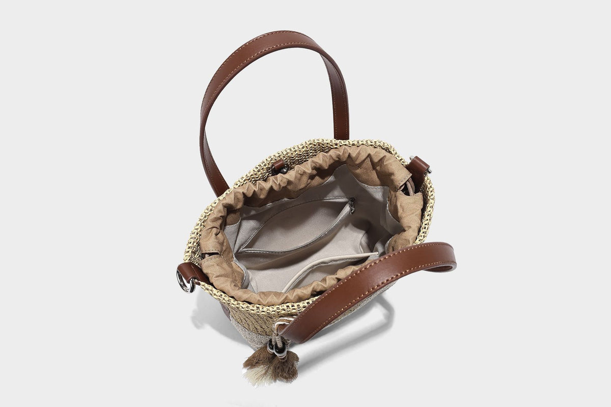 Two-tone open-weave tote bag in beige and cream with brown leather-look handles, tassel bead charm, and detachable