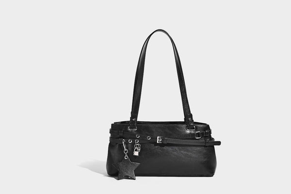 Structured glossy leather-look shoulder bag with wraparound belt straps, silver-tone hardware, and dangling star charm