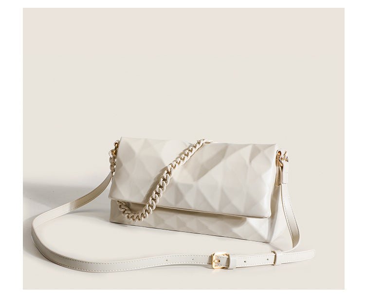 Cream white rectangular flap shoulder bag with geometric faceted surface and chunky tone-on-tone chain strap with gold-tone
