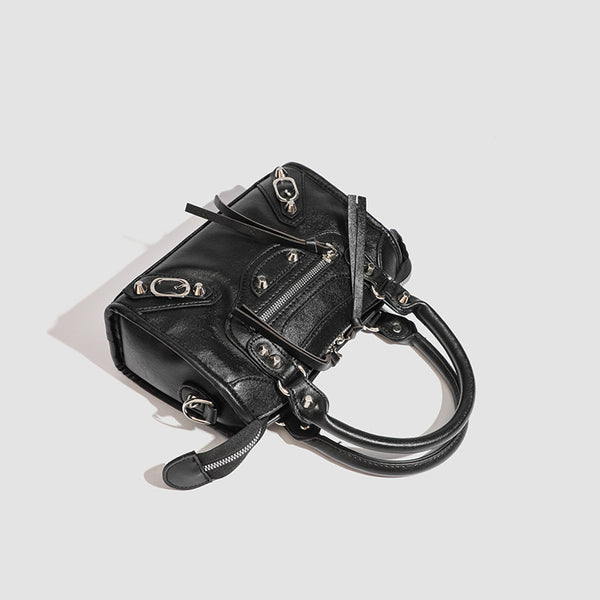 Mini-Henkeltasche mit formstabiler Silhouette, silberfarbenen Nietenbeschlägen, Reißverschlussfach vorne, zwei Tragegriffen und abnehmbarem Schulterriemen