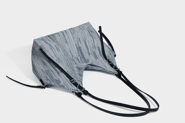 Large slouchy woven-texture shoulder tote bag with slim leather-look straps, side cinch ties, and silver-tone hardware