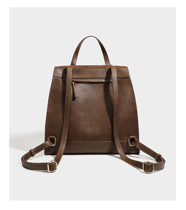 Structured suede-look convertible backpack handbag with flap closure and gold-tone emblem hardware in chocolate brown, detail
