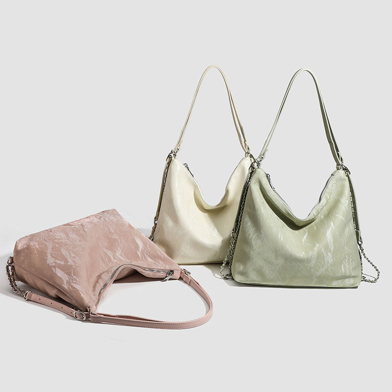 Lässige Hobo-Schultertasche mit glänzender, geknitterter Oberfläche, silberfarbenen Kettenriemen und Reißverschluss, Detailansicht 2