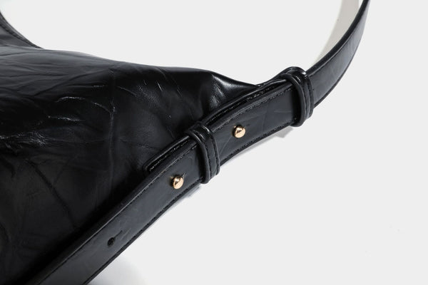 Übergroße, lässig fallende Hobo-Schultertasche aus glänzendem, geknittertem Lederimitat mit goldfarbenem Reißverschluss und Emblem-Beschlägen, Detailansicht