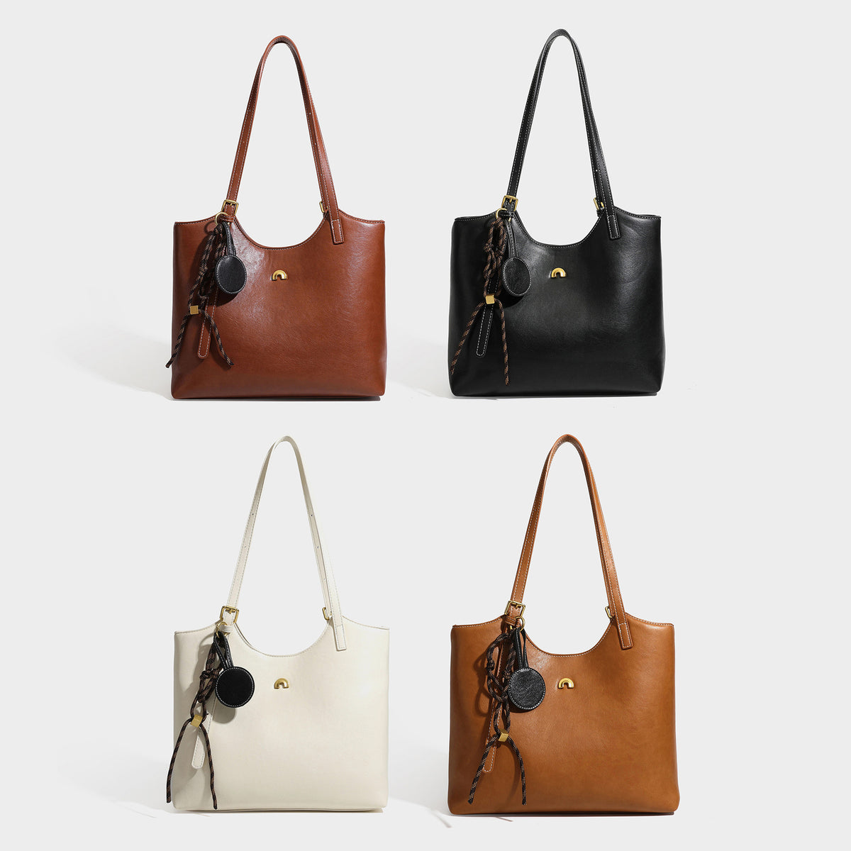 Structured smooth leather-look tote bag with long shoulder strap, gold-tone hardware, and hanging tassel-coin charm, detail