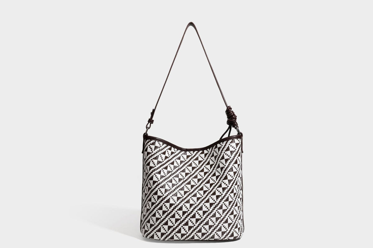 Geflochtene Schultertasche mit geometrischem Ethno-Muster, Besatz in dunkelbrauner Lederoptik, langem verstellbarem Träger und kleinem hängendem Reißverschluss