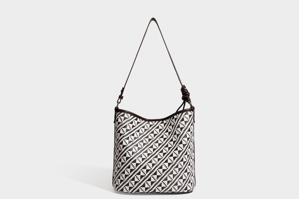 Geflochtene Schultertasche mit geometrischem Ethno-Muster, Besatz in dunkelbrauner Lederoptik, langem verstellbarem Träger und kleinem hängendem Reißverschluss
